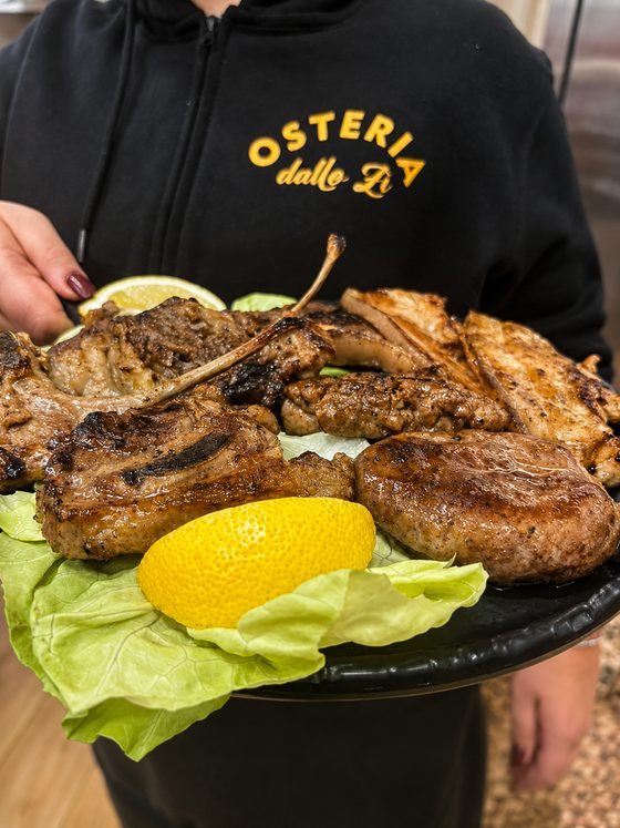 Vassoio di grigliata mista di carne con limone e insalata