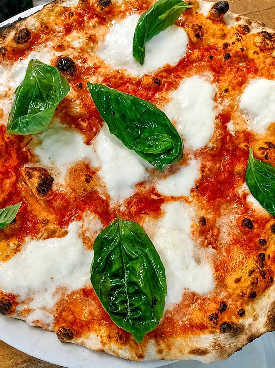 Pizza margherita con mozzarella di bufala e basilico appena sfornata