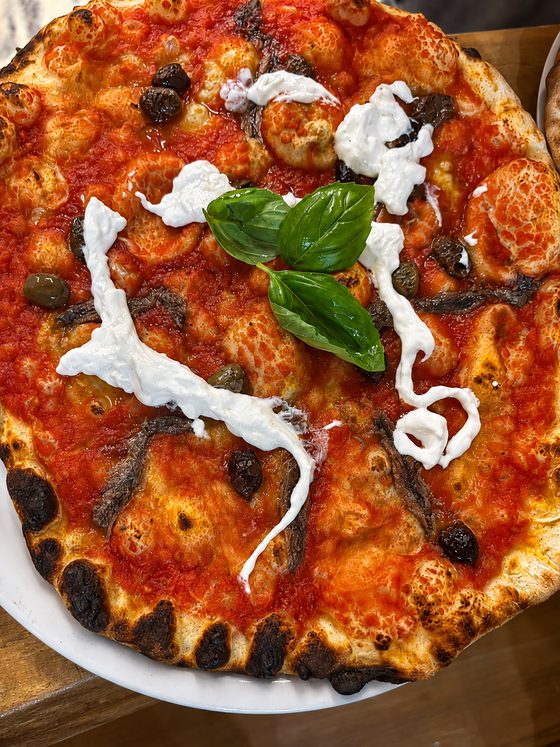 Pizza rossa con stracciatella, alici e olive