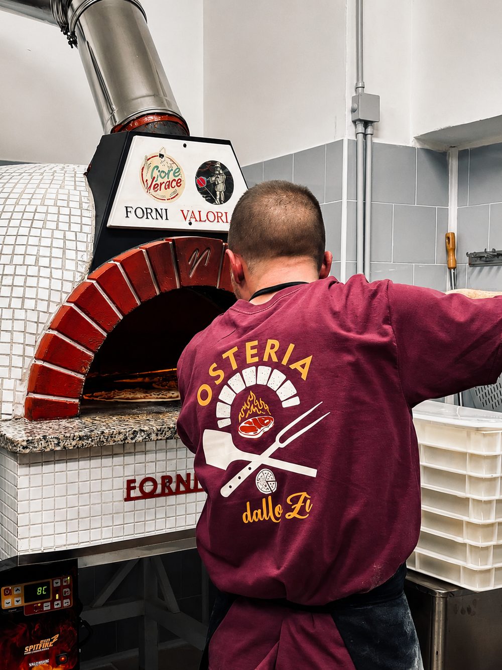 Il pizzaiolo dell'Osteria dallo Zì inforna una pizza nel forno a legna Valoriani